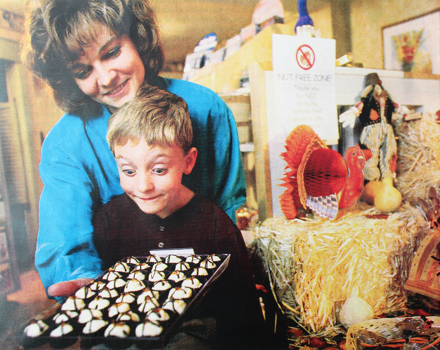 A mother and son look excitedly at a tray of white chocolate truffles